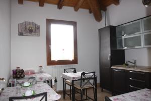 uma cozinha com mesa e cadeiras e uma janela em B&B Oasi em San Giorgio di Piano
