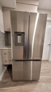 a stainless steel refrigerator in a kitchen at Elegance by Mal and Al Luxury Private Bsmt Suite in Regina +20 photos