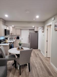 a kitchen and dining room with a table and chairs at Elegance by Mal and Al Luxury Private Bsmt Suite in Regina
