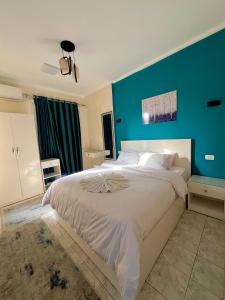 Un dormitorio con una cama grande con una pared azul. en Cozy apartment in down town, en El Cairo