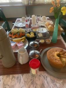 a table topped with plates of food and a cake at Solo Buziano Guest House in Búzios +11 photos