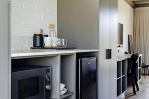 a kitchen with a counter top with a microwave at Black Dolphin Motel in Merimbula