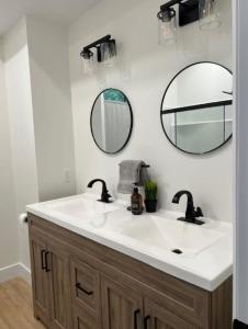 Tubside Tranquility Tobermory Winter Retreat في توبيرموري: حمام مع مغسلة بيضاء ومرآتين +17 صورة