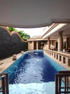 Vila Sentul Private pool 7bedroom,Privatepool tennis meja, Billiard, 0813delapannolsatuenam4151 في Gadok 1: حمام سباحة في وسط المبنى