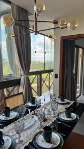 uma mesa de jantar com pratos e copos e uma janela em Refugio em bananeiras em Bananeiras