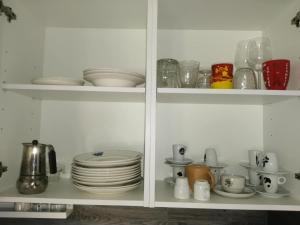 a white cabinet filled with plates and dishes at Casa dos Sonhos Glamping in Lagoa