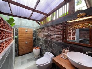 un bagno con un lavandino e un water al suo interno di Nglaras Resort Yogyakarta a Ngaglik