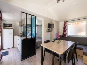 a kitchen and dining room with a table in a room at Mobil-home confortable avec terrasse pour 5 personnes - API-1-52-916 in Saint-Rome-de-Tarn