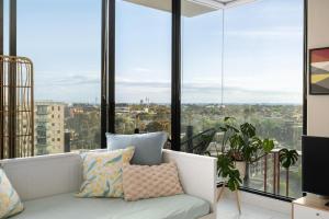 a living room with a couch and large windows at Ocean view apartment close to CBD with indoor pool. in Melbourne