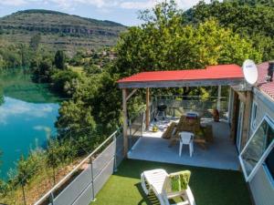 a house with a deck with a view of a lake at Mobil home 28m² à Saint-Rome-de-Tarn - Terrasse - API-1-52-943 in Saint-Rome-de-Tarn