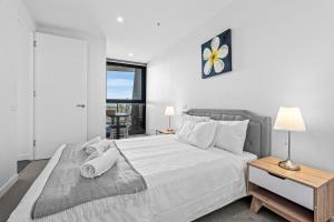 Galleria on the Glen - High floor deluxe apartment في غلين وافرلي: غرفة نوم بسرير كبير ونافذة