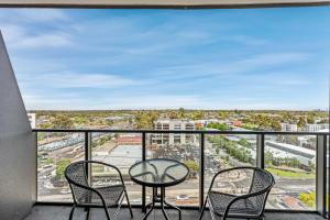 Galleria on the Glen - High floor deluxe apartment في غلين وافرلي: شرفة مع طاولة وكراسي وإطلالة على المدينة