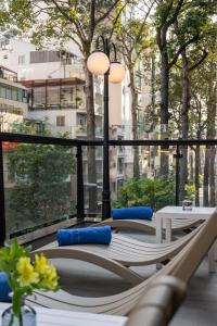 eine Gruppe von Stühlen und Tischen auf einem Balkon in der Unterkunft Harmony Saigon Hotel & Spa in Ho-Chi-Minh-Stadt