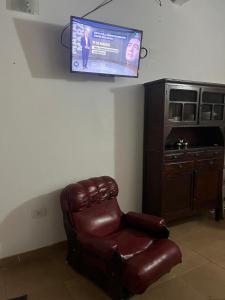 サンタ・テレシータにあるLo de Nelly en Santa Teresita Pta Bajaの壁にテレビが掛かっている茶色の革張りの椅子