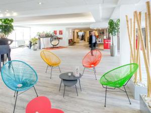 ein Raum mit Stühlen und Tischen in einer Lobby in der Unterkunft Novotel Perpignan Nord Rivesaltes in Rivesaltes