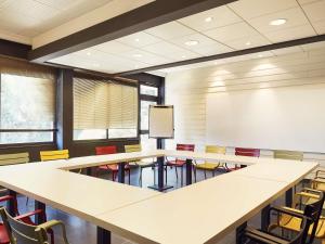 滨海拉塞讷Ibis styles Toulon la Seyne sur Mer的一个带桌椅的教室和白色板 更多40张照片