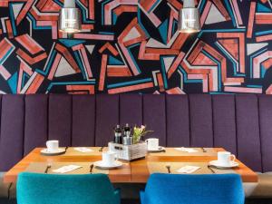 a dining room with a table and blue chairs at Mercure Hotel Berlin City West in Berlin