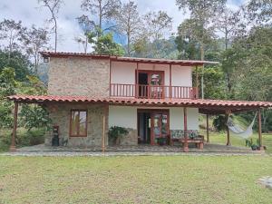 a small house with a balcony on top of it at Rural Cabin Among Clouds Támesis in Támesis