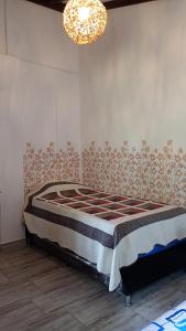 Rural Cabin Among Clouds في Támesis: سرير في غرفة مع ثريا