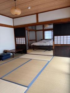 ŌwadaにあるHostel Inn かすみがうら 仁左ェ門のベッドのある部屋と床にマットが敷かれた部屋