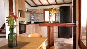 a kitchen with a table and a vase with flowers at Rural Cabin Among Clouds Támesis in Támesis