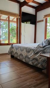 Rural Cabin Among Clouds في Támesis: غرفة نوم بها سرير في غرفة بها نوافذ