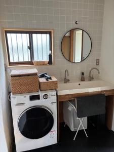 ŌwadaにあるHostel Inn かすみがうら 仁左ェ門の洗濯機と洗面台を備えたバスルーム