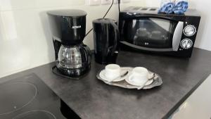 blat z 2 filiżankami kawy i kuchenką mikrofalową w obiekcie Les Zamours Des Lianes w mieście Saint-Joseph