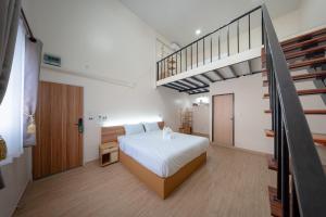 a bedroom with a bed and a staircase at The Nook Hotel in Chiang Mai