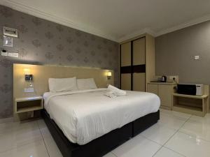 a bedroom with a large white bed in it at Kesuma Villa Exclusive Stay in Parit Raja