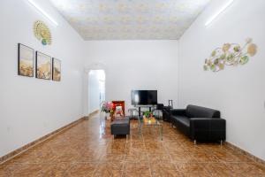 a living room with a couch and a tv at Hà Giang Homestay - Nhà phố Du lịch Biển Vũng Tàu Gần bãi biển Long cung in Vung Tau