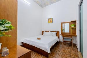 a bedroom with a bed and a table and a mirror at Hà Giang Homestay - Nhà phố Du lịch Biển Vũng Tàu Gần bãi biển Long cung in Vung Tau