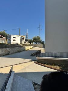 Una persona camina por una acera cerca de un edificio. en Vlore Radhimë Vacation Home, en Vlorë 2 fotos más