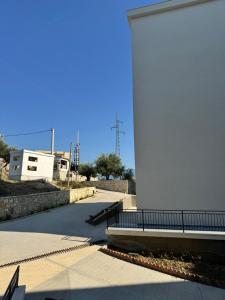 Un edificio blanco con una valla junto a una acera en Vlore Radhimë Vacation Home, en Vlorë