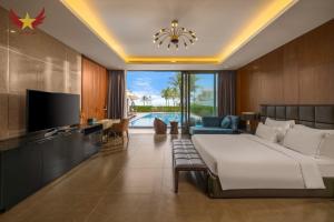 a bedroom with a bed and a tv and a living room at The Five Stars Villa 7 Bedrooms Beachfront in Danang