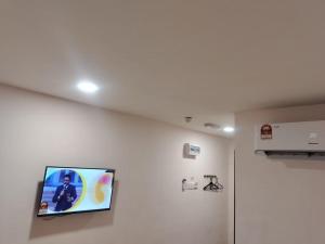 Ein Flachbildfernseher hängt an einer weißen Wand in der Unterkunft MORNINGS HOTEL in Sungai Petani