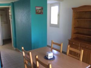 Un comedor con una mesa de madera y una ventana. en Chalet avec terrasse pour 4 personnes à Oloron-Sainte-Marie - API-1-52-954, en Bidos