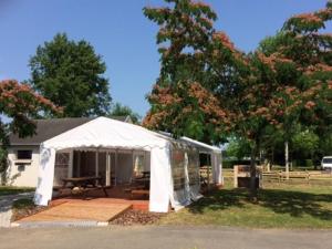 Una carpa blanca con una mesa de picnic en un patio. en Chalet avec terrasse pour 4 personnes à Oloron-Sainte-Marie - API-1-52-954, en Bidos