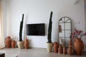 ein Zimmer mit vielen Vasen und einem Fernseher in der Unterkunft Desert Retreat Canal View walk to F1 Yas Island in Abu Dhabi