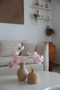 ein weißer Tisch mit einer Vase mit Blumen darauf in der Unterkunft Desert Retreat Canal View walk to F1 Yas Island in Abu Dhabi