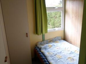 a small bed in a room with a window at Chalet 3 Chambres avec Terrasse - Parfait pour 6 Personnes - API-1-52-991 in La Chapelle