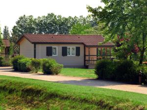 a small house in a yard with a driveway at Chalet pour 6 pers avec terrasse au Domaine du Lac de Champos - API-1-52-1001 in Charmes-sur-lʼHerbasse