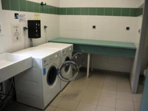 a laundry room with a washing machine and a sink at Chalet pour 6 pers avec terrasse au Domaine du Lac de Champos - API-1-52-1001 in Charmes-sur-lʼHerbasse +18 photos