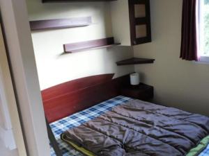 a small bedroom with a bed in a room at Mobil-home 6 personnes avec terrasse à La Chapelle-devant-Bruyères - API-1-52-1002 in La Chapelle +19 photos