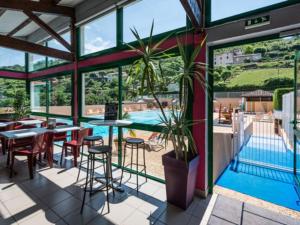 Un restaurante con piscina, mesas y sillas. en Mobil-home PMR avec Terrasse à Saint-Rome-de-Tarn - API-1-52-1012, en Saint-Rome-de-Tarn