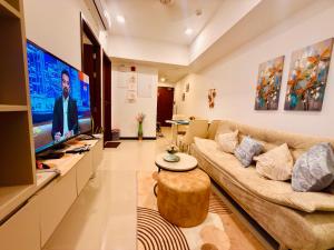 a living room with a couch and a flat screen tv at Trizen Colombo stylish high rise condo -Vistablu 32 in Colombo