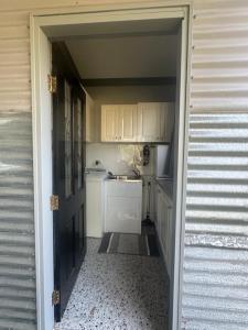 an open door to a kitchen with white cabinets at Quiet Rural Retreat - Kimbriki in Mount George