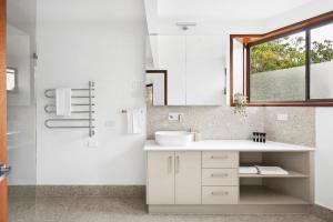 a white bathroom with a sink and a window at Clifton Retreat large family home new renovation in Clifton Springs