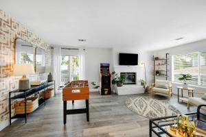 Leucadia's Beach House w Game Room في إنسينيتاس: غرفة معيشة مع طاولة ومدفأة
