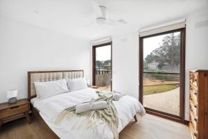 a bedroom with a bed and a large window at Clifton Retreat large family home new renovation in Clifton Springs